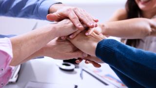 Ihmisillä kädet päällekkäin.