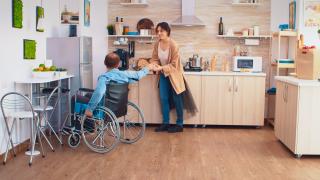 Henkilö pyörätuolissa keskustelee toisen henkilön kanssa