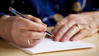 Nainen kirjoittaa kirjettä.