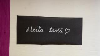 Kuvassa seinällä lappu, jossa lukee aloita tästä