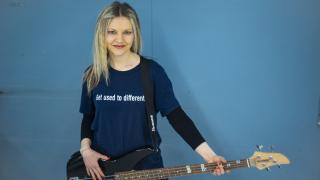 Henkilö pitää bassoa kädessään.