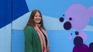 Henkilö seinän edessä