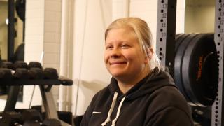 Henkilö hymyilee kuntosalilla