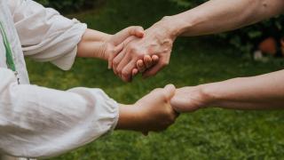 Henkilöt pitävät käsistä kiinni.