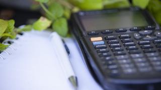 Laskin sekä kynä ja paperia