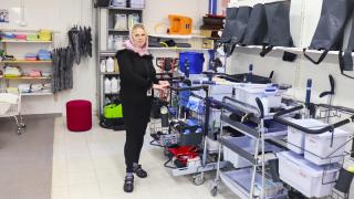 Henkilö siivousvälineiden vieressä