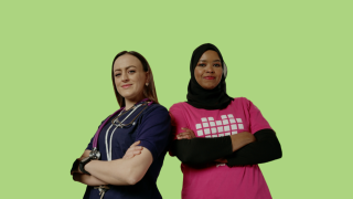 VAKEn lähihoitajat Naimo ja Enise poseeraavat kuvassa sankarillisesti, työasut päällä. Tausta on vihreä.