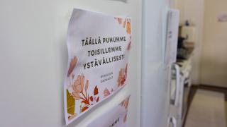 Täällä puhumme toisillemme ystävällisesti -lappu