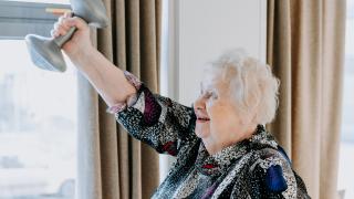 Vanhempi nainen nostaa punttia.