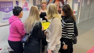 Kuvassa henkilöitä seisomassa ringissä.