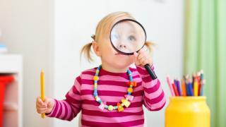 Lapsi katsoo suurennuslasin läpi