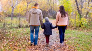 Perhe kävelee ulkona syksyllä
